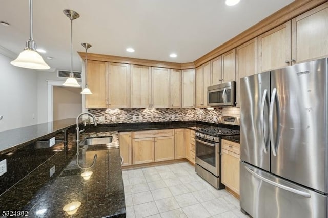 kitchen featuring tasteful backsplash, light brown cabinets, appliances with stainless steel finishes, and a sink