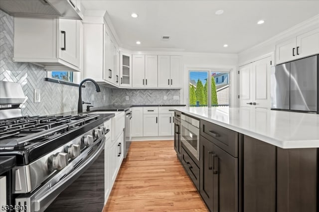 kitchen featuring white cabinetry, a wealth of natural light, light hardwood / wood-style flooring, and appliances with stainless steel finishes