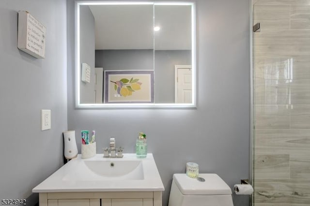 bathroom featuring vanity, a shower, and toilet