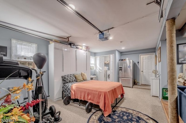 bedroom featuring multiple windows, light colored carpet, stainless steel fridge, and washer and clothes dryer