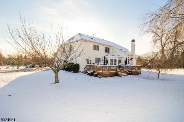 snow covered house with a deck