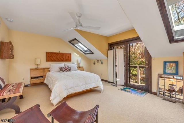 carpeted bedroom featuring ceiling fan, lofted ceiling with skylight, and multiple windows