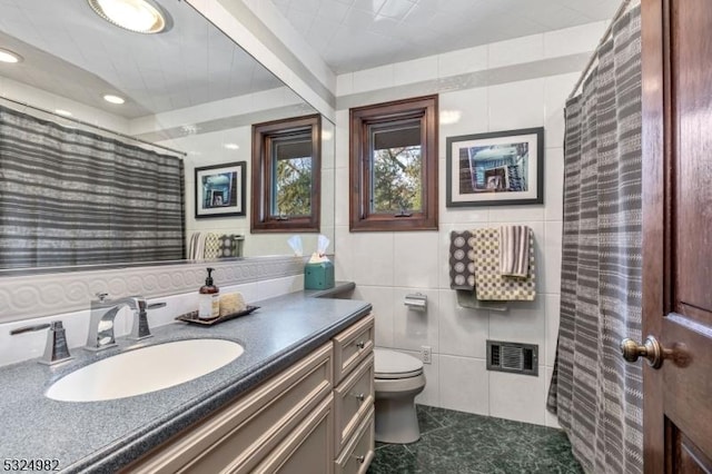 bathroom featuring a shower with shower curtain, vanity, toilet, and tile walls