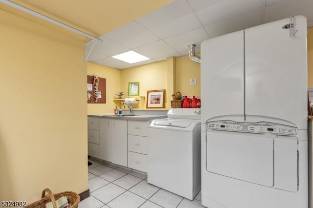 clothes washing area featuring independent washer and dryer, light tile patterned floors, and sink