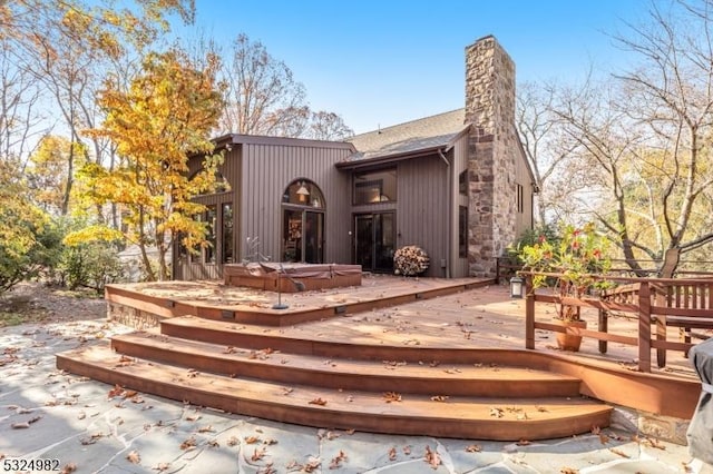 back of house featuring a hot tub and a deck