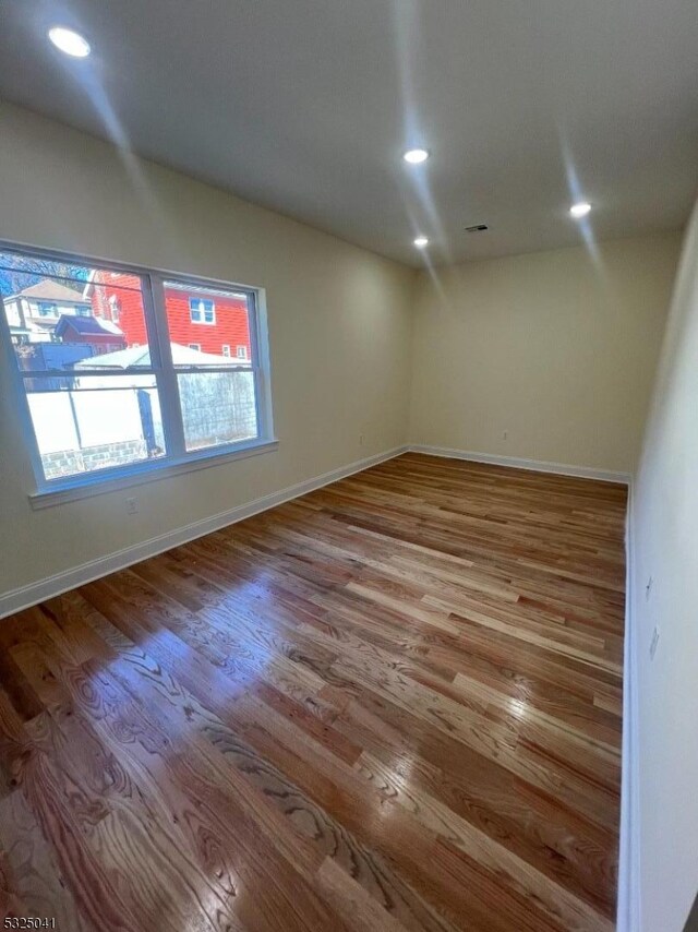 empty room with hardwood / wood-style floors