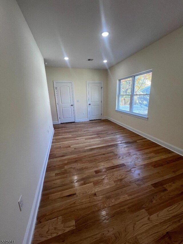 unfurnished room with hardwood / wood-style flooring