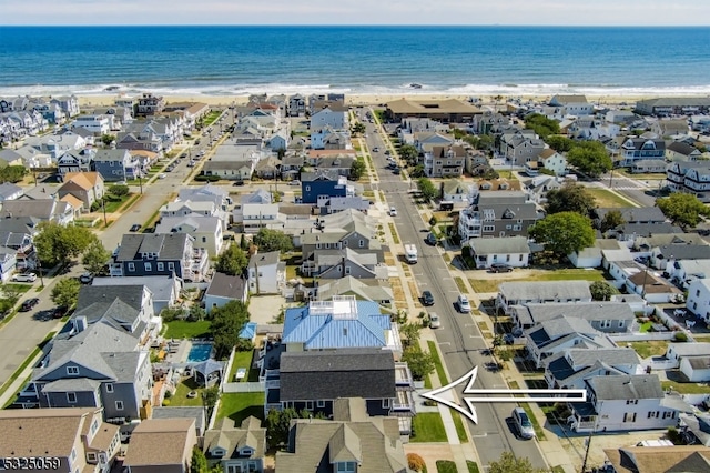 bird's eye view with a water view and a beach view