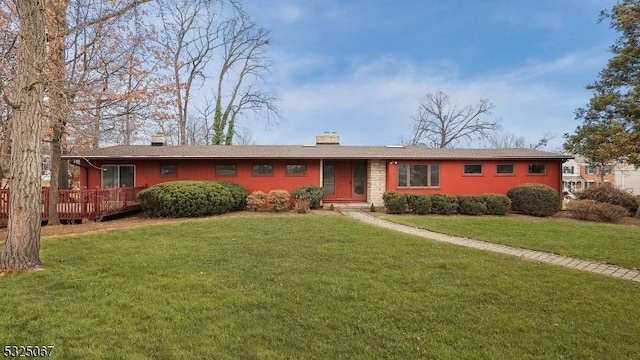 single story home featuring a wooden deck and a front yard