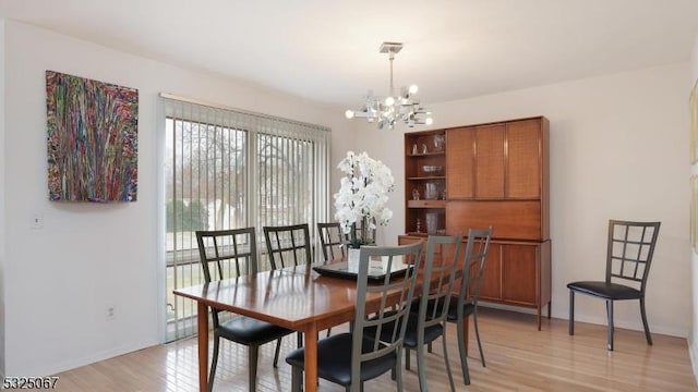 dining room with light hardwood / wood-style flooring and a chandelier