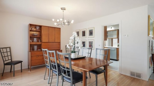 dining space featuring light hardwood / wood-style floors and a notable chandelier