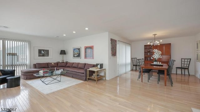 living room featuring an inviting chandelier and light hardwood / wood-style flooring