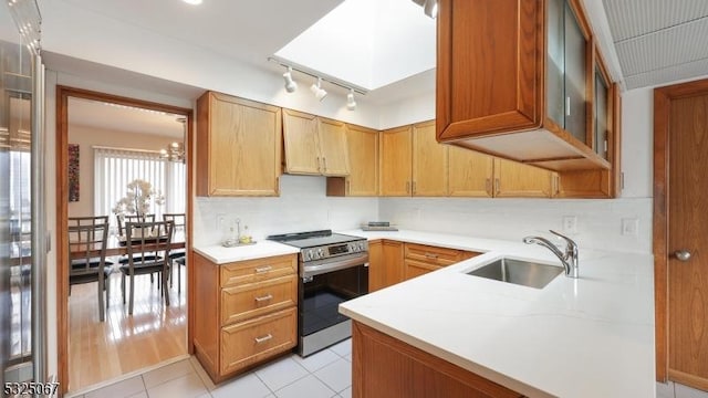 kitchen with stainless steel electric stove, a notable chandelier, sink, and light hardwood / wood-style flooring