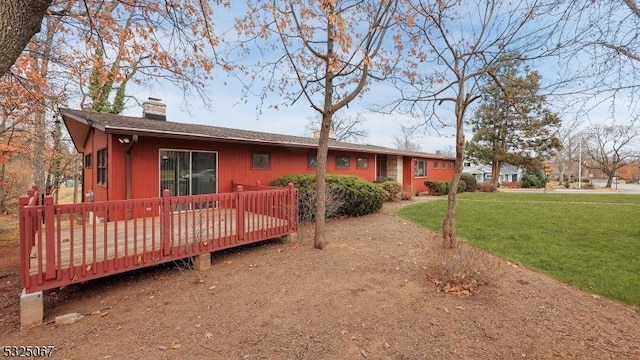 rear view of property with a lawn and a deck