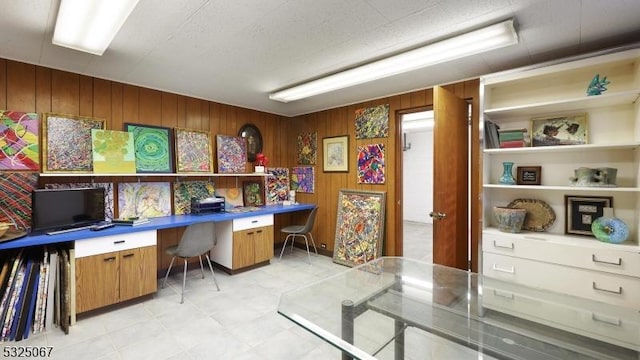 office area featuring wooden walls and built in desk