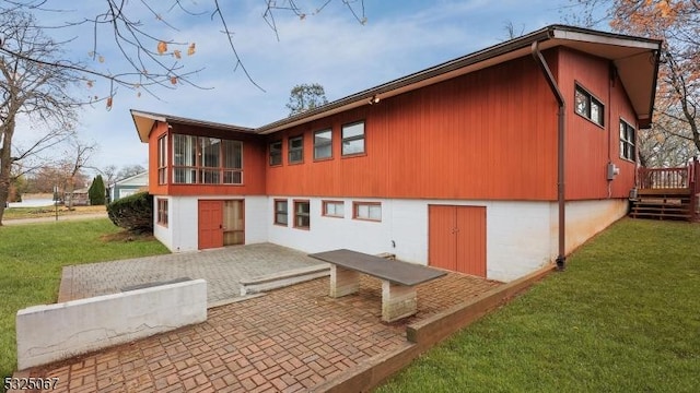 back of house with a patio area and a lawn