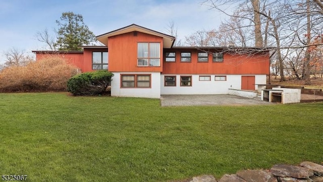 rear view of property with a lawn and a patio area