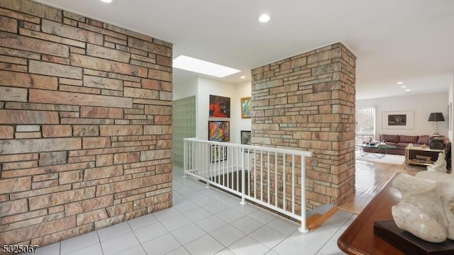 hall with a skylight and light hardwood / wood-style flooring