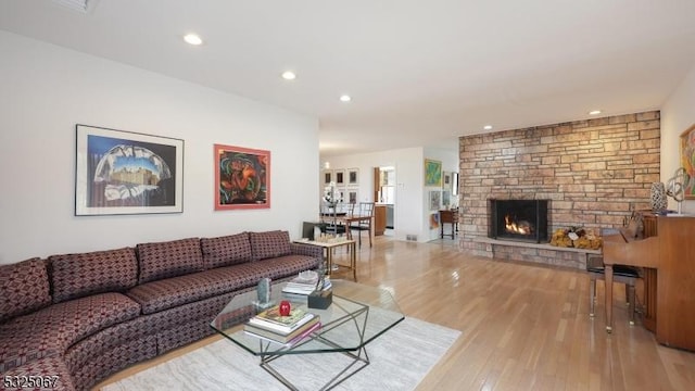 living room featuring light hardwood / wood-style floors and a stone fireplace