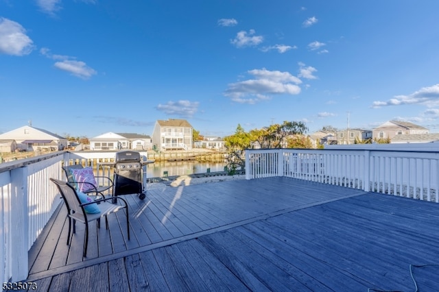 wooden deck featuring a grill and a water view