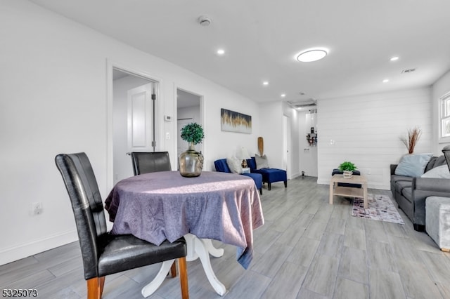 dining area featuring wood walls and light hardwood / wood-style floors