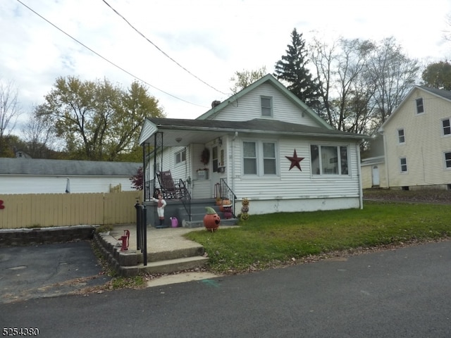 bungalow with covered porch and a front yard