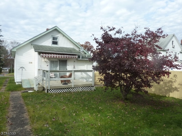 rear view of house with a deck and a lawn