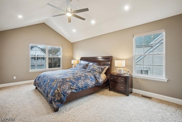 bedroom with multiple windows, light colored carpet, vaulted ceiling, and ceiling fan