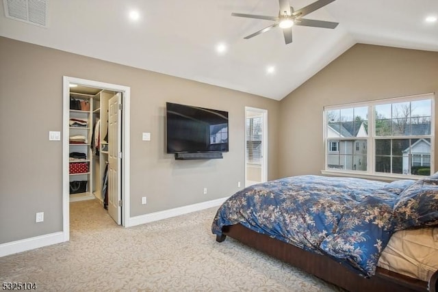 bedroom with lofted ceiling, light carpet, a walk in closet, ceiling fan, and a closet