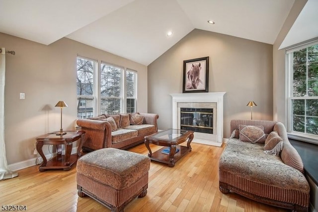 living room featuring plenty of natural light, lofted ceiling, and light wood-type flooring