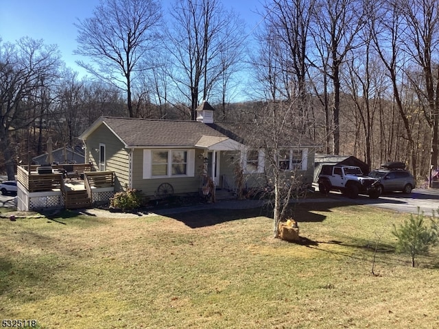 view of front of property featuring a wooden deck and a front lawn