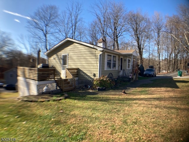 view of home's exterior featuring a deck and a yard