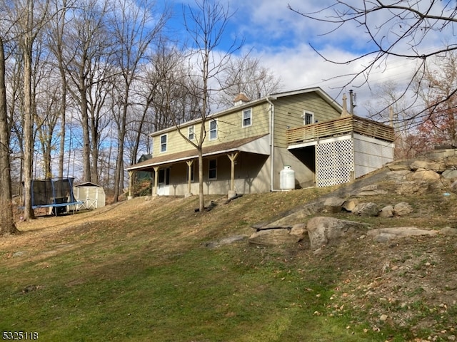 view of front of property with a deck and a trampoline