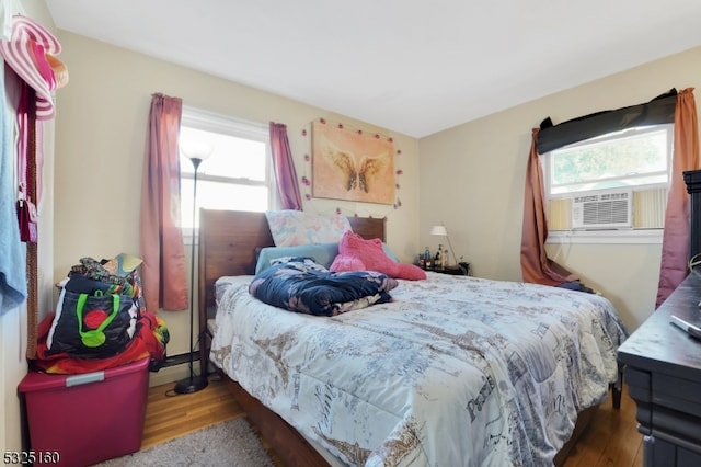 bedroom featuring cooling unit, multiple windows, and dark wood-type flooring