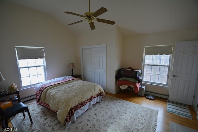 bedroom with ceiling fan, vaulted ceiling, light wood-type flooring, and multiple windows