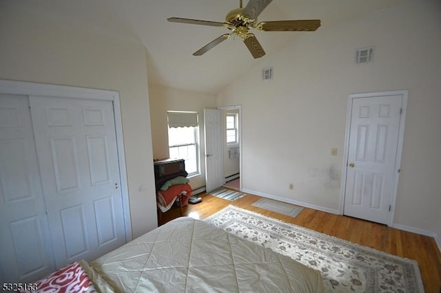 bedroom featuring ceiling fan, a closet, high vaulted ceiling, and light hardwood / wood-style floors