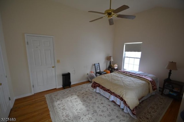 bedroom with ceiling fan, hardwood / wood-style floors, lofted ceiling, and radiator heating unit