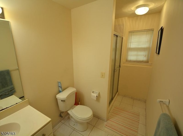 bathroom featuring toilet, vanity, tile patterned floors, and a shower with door