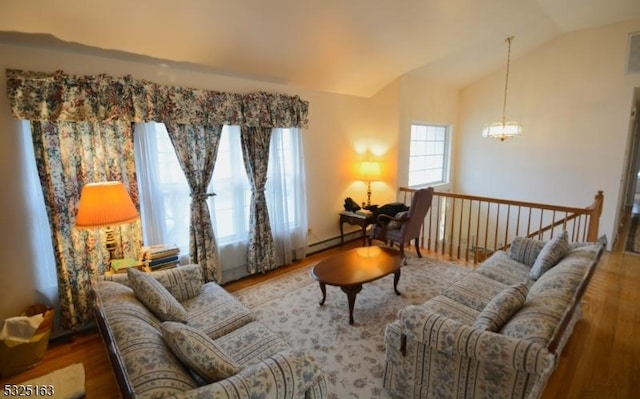 sitting room featuring hardwood / wood-style floors, an inviting chandelier, and vaulted ceiling