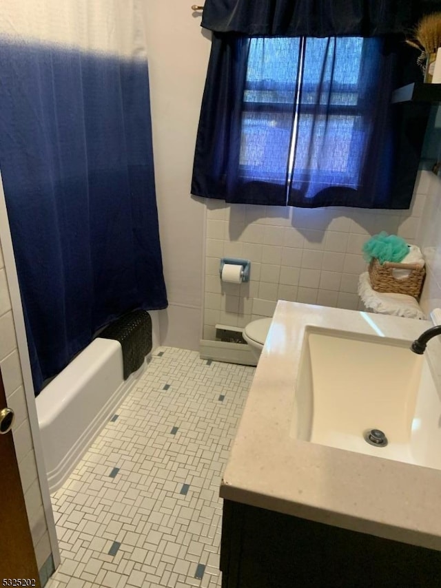 full bathroom featuring tile patterned floors, vanity, tile walls, and toilet