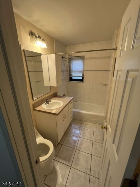 full bathroom with toilet, vanity, tile patterned floors, and tiled shower / bath