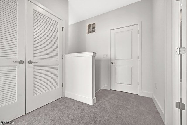 clothes washing area with light colored carpet