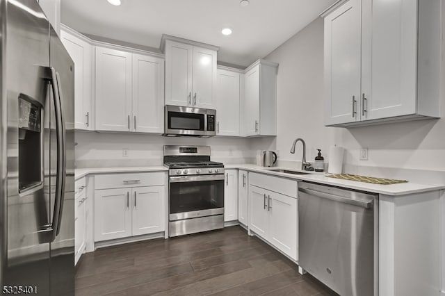 kitchen with white cabinetry, dark hardwood / wood-style flooring, sink, and appliances with stainless steel finishes