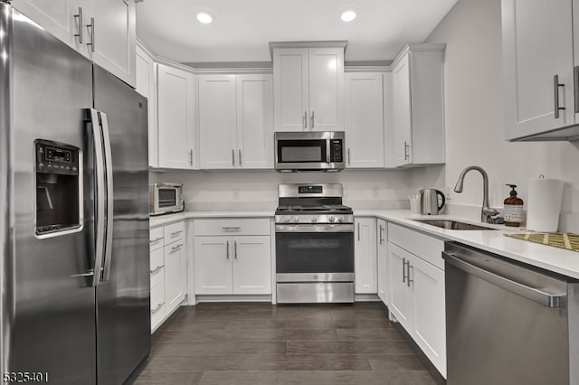 kitchen with sink, white cabinets, stainless steel appliances, and dark hardwood / wood-style floors