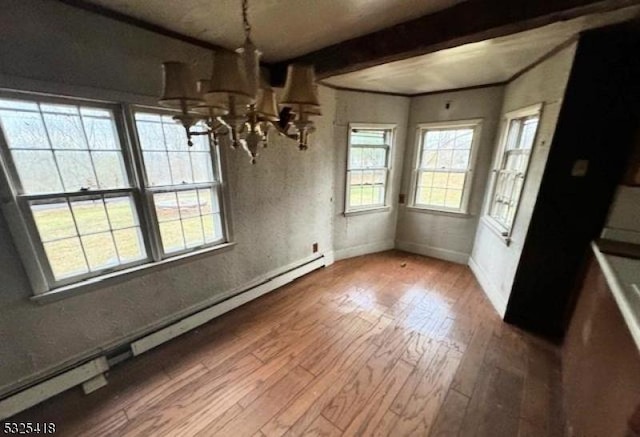 unfurnished dining area with wood-type flooring, a baseboard radiator, an inviting chandelier, and beam ceiling