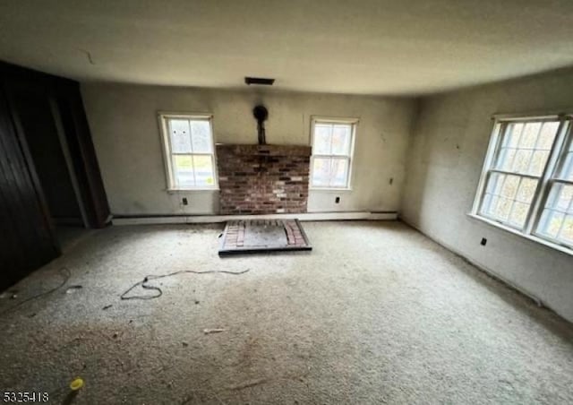 unfurnished living room featuring carpet floors and a healthy amount of sunlight