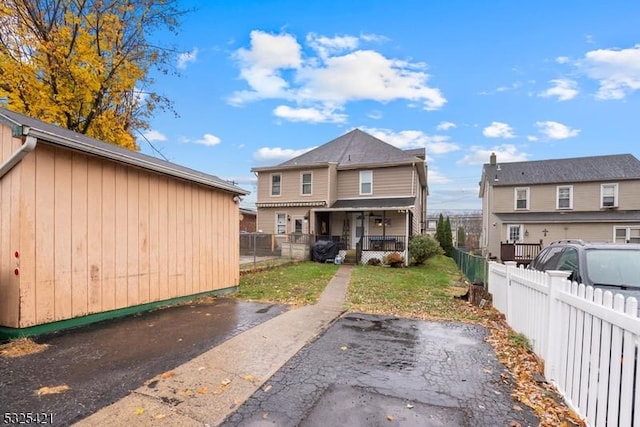 back of property featuring a porch and a lawn