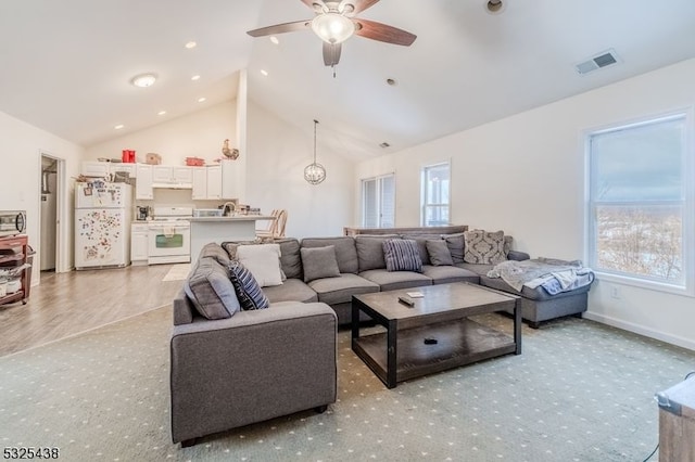 living room with a wealth of natural light, ceiling fan, light hardwood / wood-style floors, and high vaulted ceiling