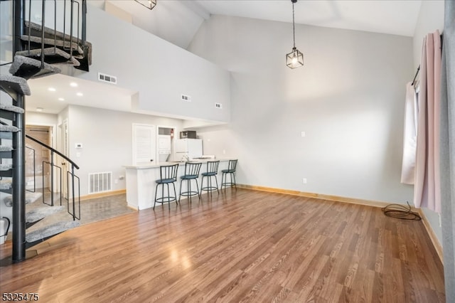 living room with high vaulted ceiling and hardwood / wood-style flooring