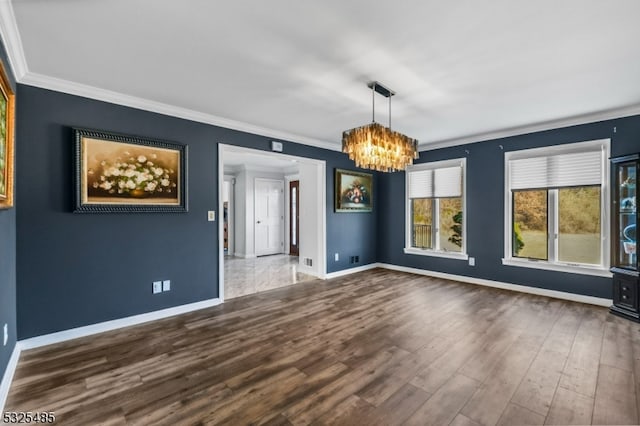 unfurnished dining area with hardwood / wood-style floors, ornamental molding, and an inviting chandelier